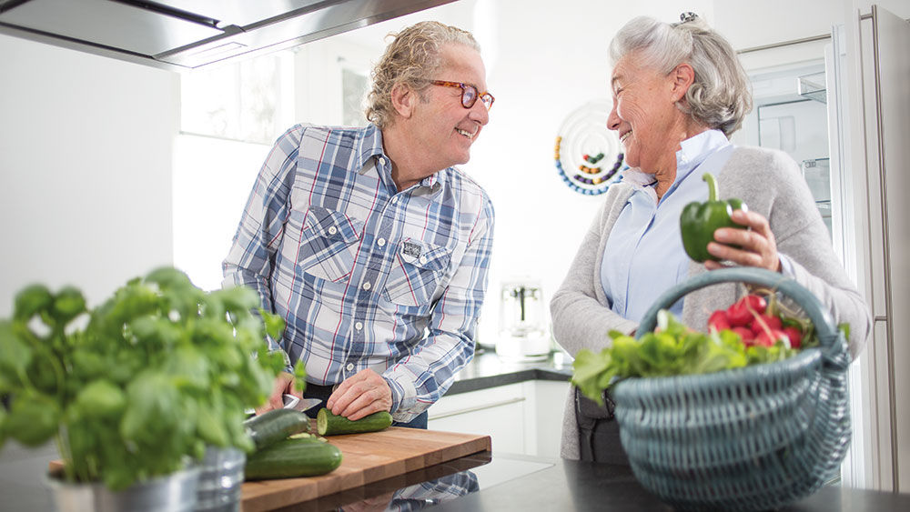 homme et femme préparent des légumes ensemble